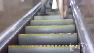 Подглядывает под юбку незнакомой блондинки на эскалаторе в метро