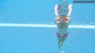 Мужчина снимает, как голая девушка плавает в бассейне